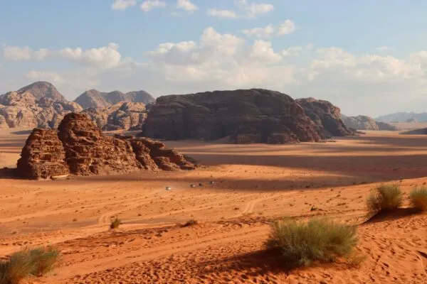 Een auto rijdt door de Wadi Rum woestijn
