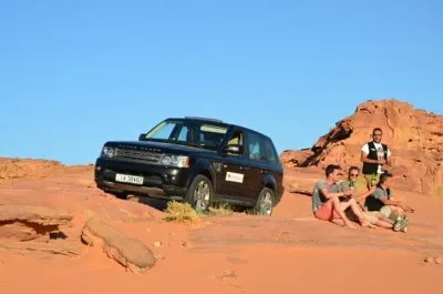 Jeep en zittende mensen in Wadi Rum Jordanië