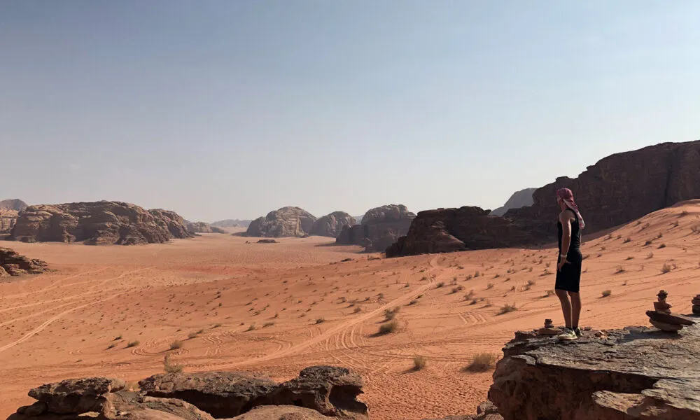Een persoon bekijkt het uitzicht van de Wadi Rum Woestijn