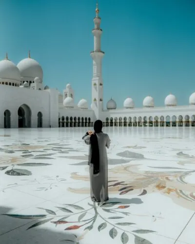Een vrouw die staat bij de Sheikh Zayed Grand Mosque in Abu Dhabi